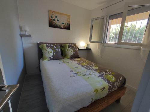 un petit lit dans une chambre avec une fenêtre dans l'établissement Appartement 2 pièces près plage avec parking sécurisé - FR-1-776-124, à Argelès-sur-Mer