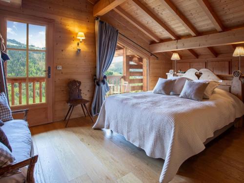 - une chambre avec un grand lit dans une cabane en rondins dans l'établissement Chalet 4 étoiles, 10 pers., spa, vue imprenable à La Clusaz - FR-1-304-301, à La Clusaz