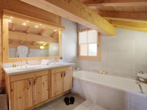 une salle de bain avec une baignoire et un lavabo dans l'établissement Chalet 4 étoiles, 10 pers., spa, vue imprenable à La Clusaz - FR-1-304-301, à La Clusaz