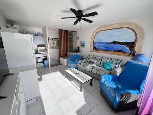un salon avec un canapé et un ventilateur de plafond dans l'établissement Appartement T2 avec Terrasse et Parking, à 50m de la Plage - FR-1-702-70, au Cap d'Agde