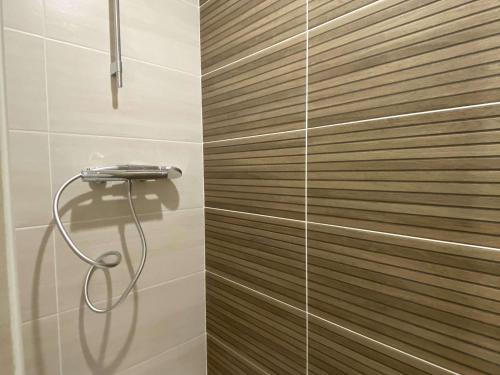 une douche dans une salle de bain avec un mur en bois dans l'établissement Appartement T3 moderne avec terrasse et parking sécurisé - FR-1-553-293, à Balaruc-les-Bains