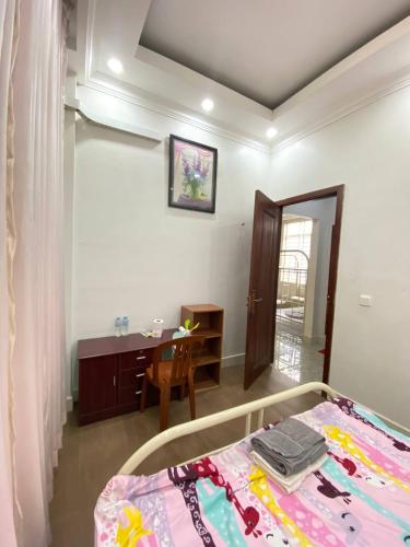 a bedroom with a bed and a table and a desk at Combretrata in Phnom Penh
