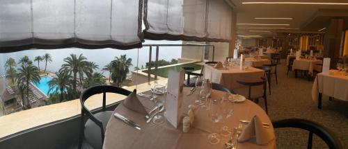 a restaurant with tables and chairs with a view of the ocean at Palace Bonanza Playa Resort & SPA by Olivia Hotels Collection in Illetas