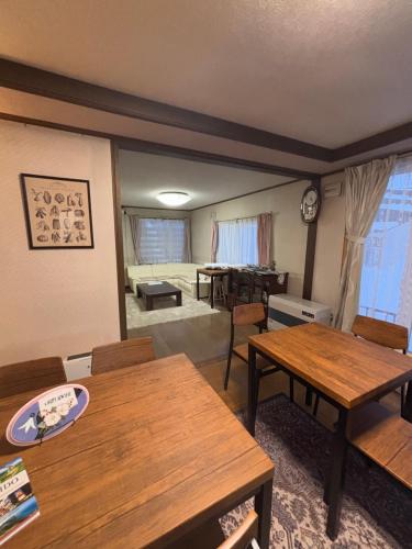 a living room with tables and a dining room at シマエナガニセコ in Kutchan