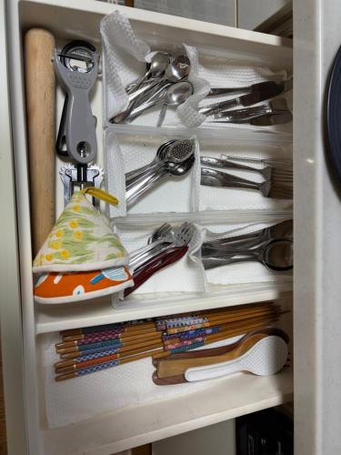 a drawer full of utensils in a cabinet at シマエナガニセコ in Kutchan