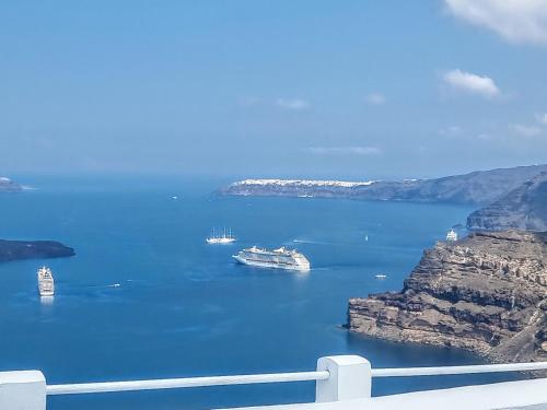 a view of a bay with ships in the water at Hotel Pleasure Black Beach Perissa Santorini in Perissa