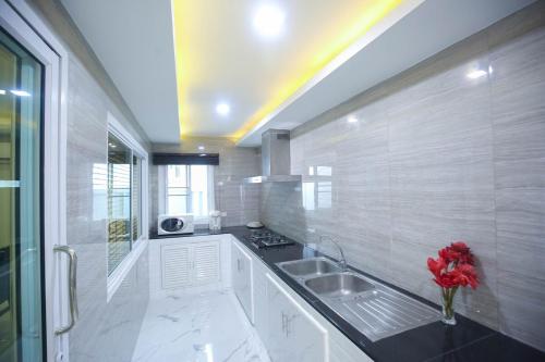 a large white kitchen with a sink and a window at Pool Villa near Chiang Mai city with WiFi in Saraphi