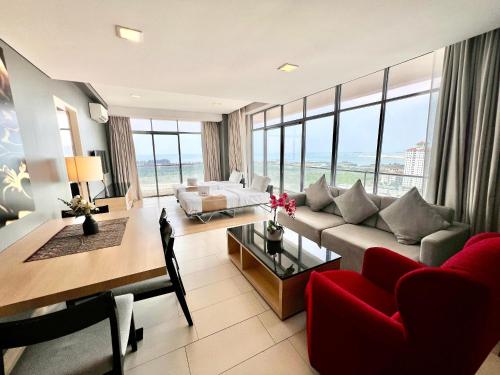 a living room with a red couch and a red chair at ASIA MELAKA HOTEL managed by The Straits Hotel & Suites 马六甲亚逸酒店 in Melaka