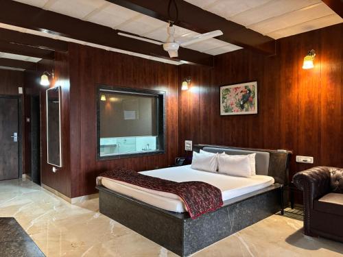 a bedroom with a bed and a tv on the wall at The Green Gate Resort Mulshi in Pune