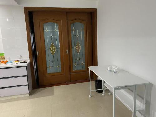 a kitchen with a wooden door and a white table at Huinan Accommodation, Close to Airport, Disney Resort, Wild Animal Park, Near Metrol 16 in Shanghai