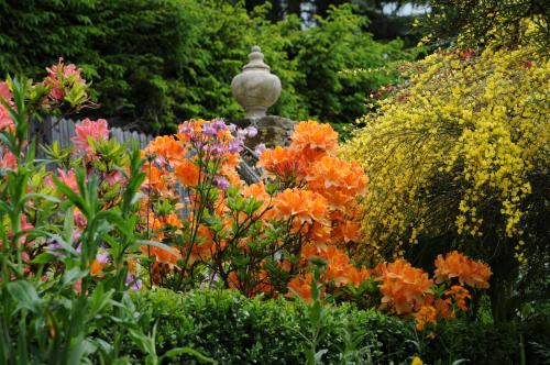 a garden of flowers with a statue in the middle at Sulamith Ferienhaus mit Garten in Sankt Kathrein am Offenegg