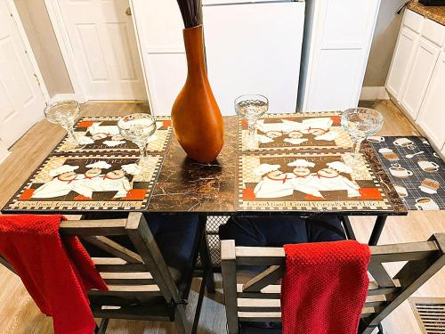 a dining room table with a vase and a table with chairs at Cozy 3BR Getaway in Conway PA in Conway