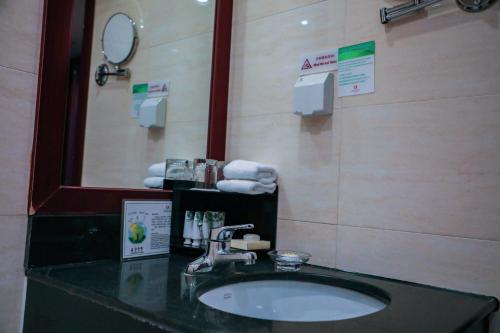 a bathroom with a sink and a mirror and towels at Jianguo Qianmen Beijing in Beijing