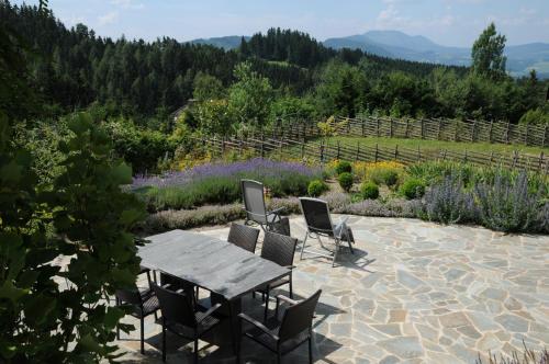 a stone patio with a wooden table and chairs at Sulamith Ferienhaus mit Garten in Sankt Kathrein am Offenegg