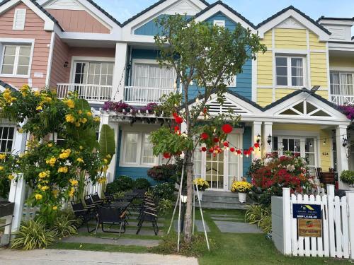 a colorful house with a white fence and flowers at Beach Villa Thiên Ngọc- Novaworld Phan Thiết in Bình Tú