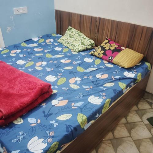 a bed with a blue comforter and two pillows on it at Gaurangi dham in Mathura