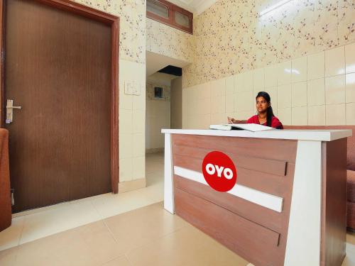a woman sitting at a counter in a room at Hotel O Behl Ashiana in Amritsar