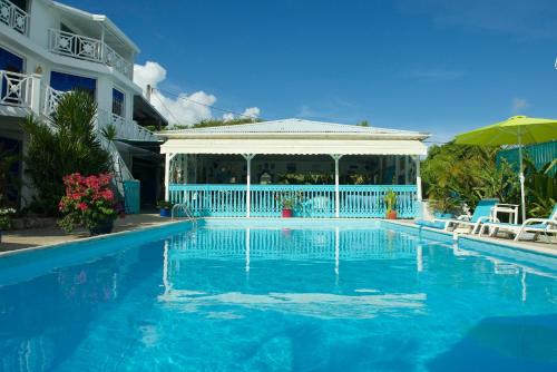 a swimming pool with a gazebo next to a building at Hotel Cap Sud Caraibes in Le Gosier