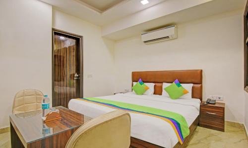 a bedroom with a bed and a desk and a bed at Itsy Hotels Prime Stay in New Delhi