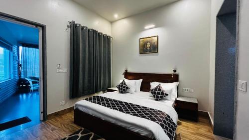 a bedroom with a bed and a large window at Vanhills - Luxury Home Stay in Jim Corbett in Kota Bāgh