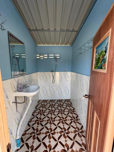 Un baño con lavabo, inodoro y espejo. en Riverland Camp, en Phumĭ Chheutéal (2)