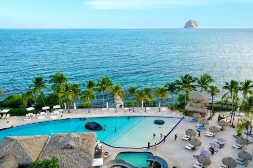 une vue aérienne d'une piscine à côté de l'océan dans l'établissement Appartement charmant au Diamant 30 m² avec vue mer, au Diamant