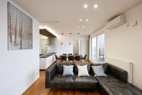 a living room with a leather couch and a table at furano frame in Furano