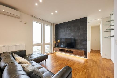 a living room with a leather couch and a television at furano frame in Furano