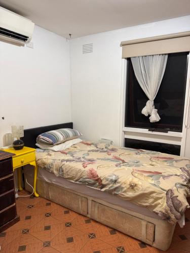 a bedroom with a bed and a window at Single room with shared bathroom 2 in Springvale South