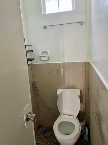 a small bathroom with a toilet and a window at Thomasita's Homestay in General Luna