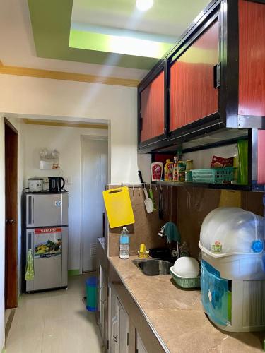 a kitchen with a sink and a refrigerator at Thomasita's Homestay in General Luna