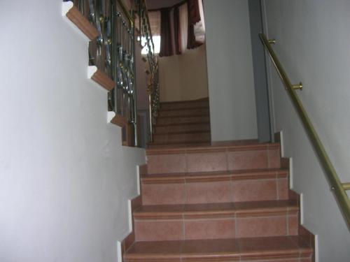 a stairway with brown stairs with green railings at Balatoni Panoráma Villa in Balatonalmádi
