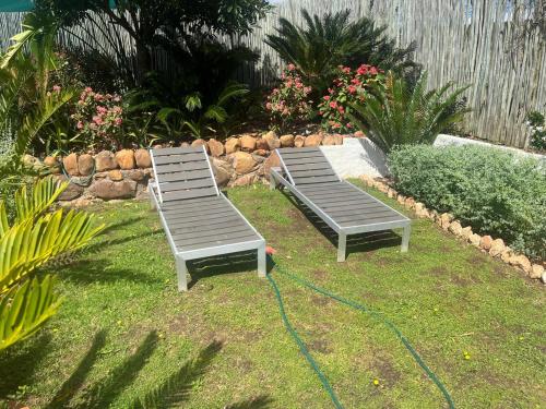 two beds sitting in the grass in a garden at Aan de Bergen in Swellendam