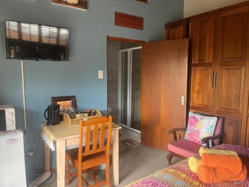 a room with a table and a chair and a desk at Aan de Bergen in Swellendam