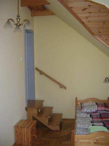 a bedroom with a bed and a wooden staircase at Balatoni Panoráma Villa in Balatonalmádi