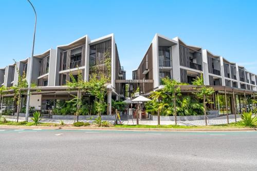 an apartment building with trees in front of a street at Jonson Lane Apartments in Byron Bay