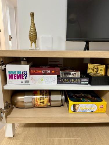 a book shelf filled with books and a tv at Levida Living - Cozy 2 Bedroom Suite at the Heart of Langley in Langley
