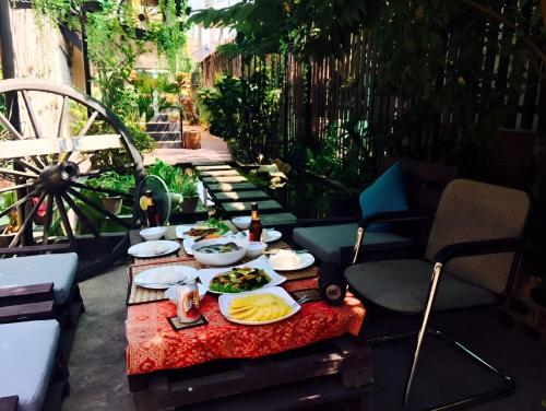 a table with plates of food on a patio at Old Khmer House in Siem Reap