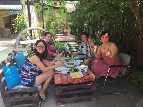 a group of people sitting around a table eating food at Old Khmer House in Siem Reap