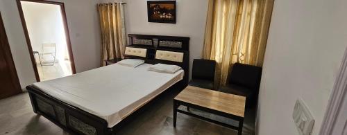 a small bedroom with a bed and a table at Prashanth kuteer in Hyderabad