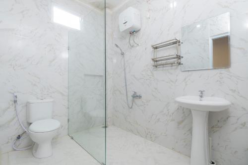 a white bathroom with a toilet and a sink at Villa Fiorenza II in Sampal 2