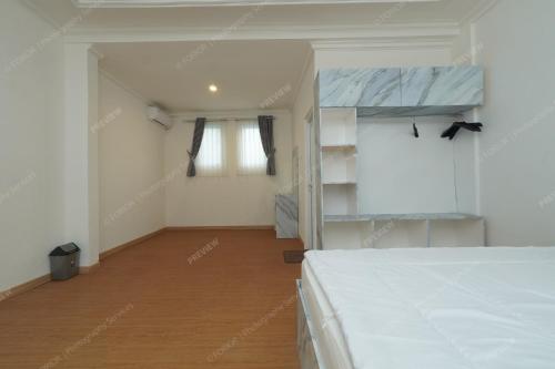 a bedroom with a white bed and a wooden floor at Villa Fiorenza II in Sampal 2