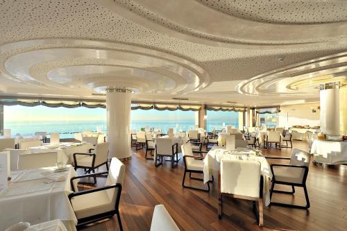 un restaurant avec des tables et des chaises blanches et un plafond dans l'établissement Vincci Selección Aleysa, à Benalmádena