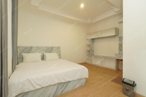 a white bedroom with a bed and a tv at Villa Fiorenza II in Sampal 2