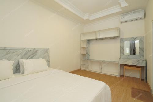 a white bedroom with a large bed and a mirror at Villa Fiorenza II in Sampal 2