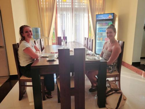 two women sitting at a table in a restaurant at Bigcity Villa - Airport Transit Hotel in Katunayake