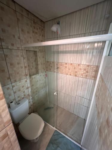 a bathroom with a toilet and a glass shower at Suíte por do sol 3 privada casa compartilhada in Xangri-lá