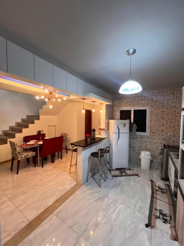 a kitchen and living room with a refrigerator and a table at Suíte por do sol 3 privada casa compartilhada in Xangri-lá