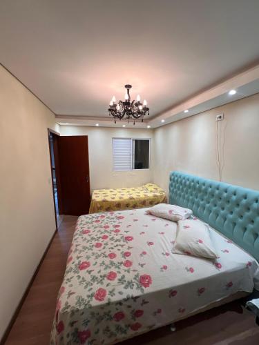 a bedroom with a bed and a chandelier at Suíte por do sol 3 privada casa compartilhada in Xangri-lá