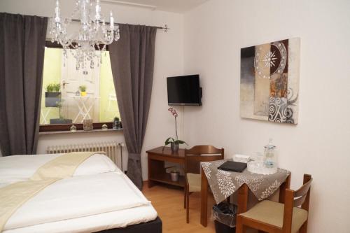 um quarto com uma cama, uma mesa e uma janela em Hotel Restaurant Zunftstube em Saarburg